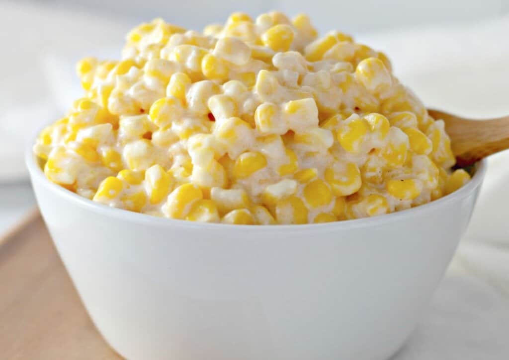 White bowl full of slow cooker creamy corn. A graet side dish. 