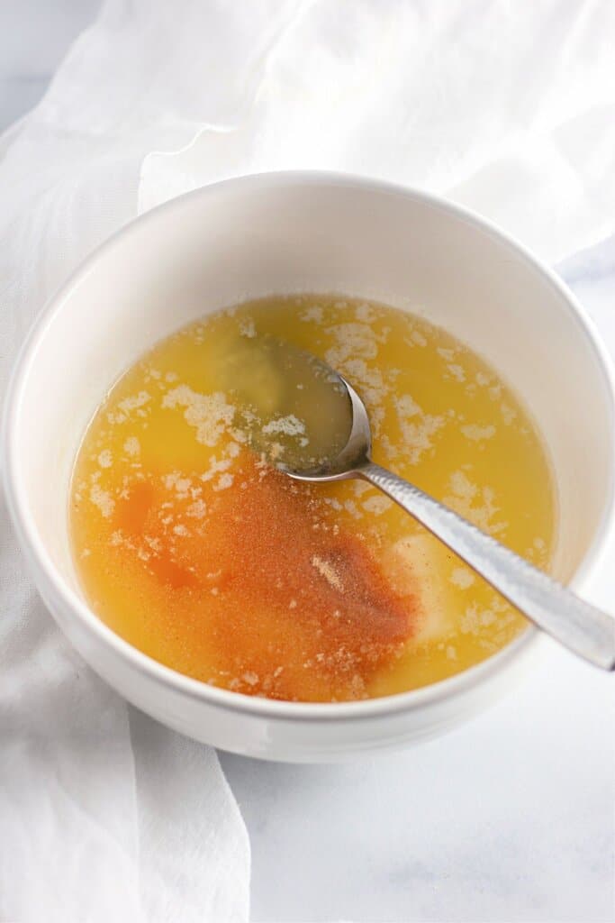 Butter and garlic powder being mixed in a small bowl.