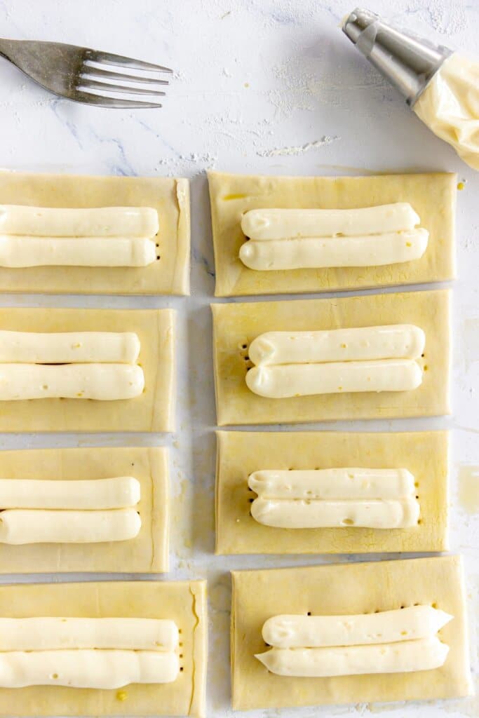 Cream cheese being piped on top of a puff pastry.