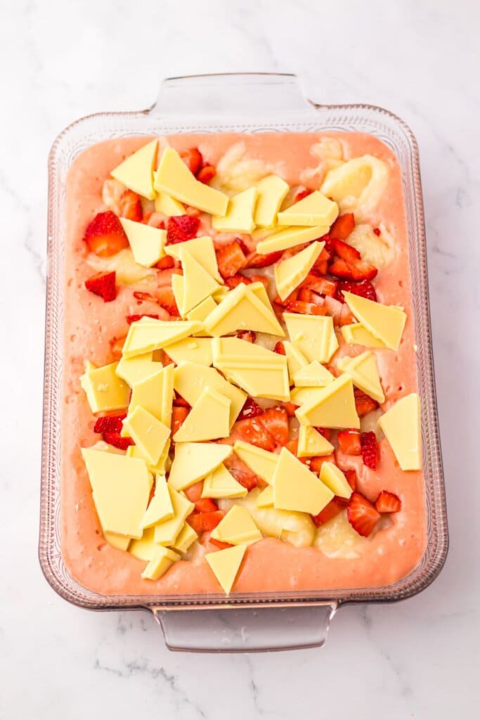 White chocolate and diced strawberries in a baking dish.