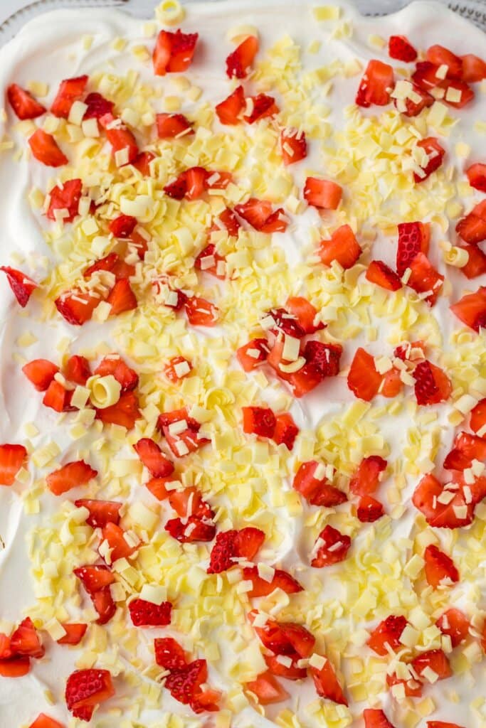 White chocolate curls being sprinkles on top of a dessert.