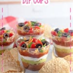 7 Layer dip cups and tortillas chips on a counter.