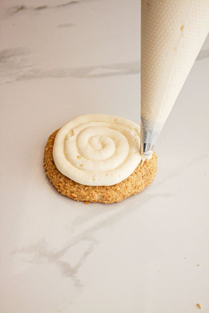 Frosting being swirled on top of cookies.