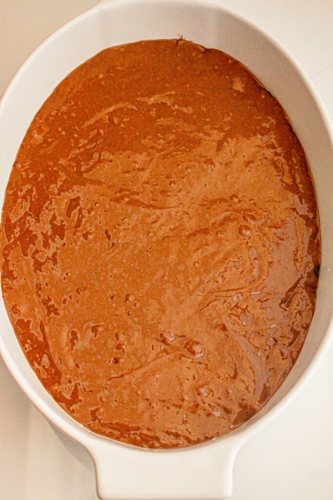 Chocolate batter in a white baking dish.