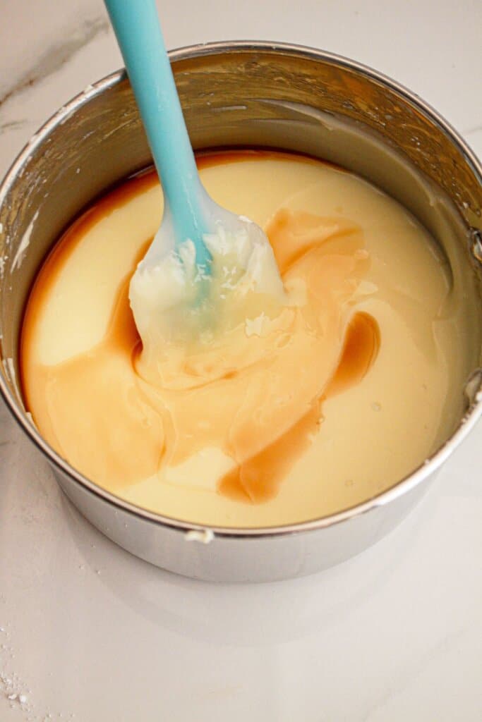 Cream cheese and vanilla in a glass mixing bowl.