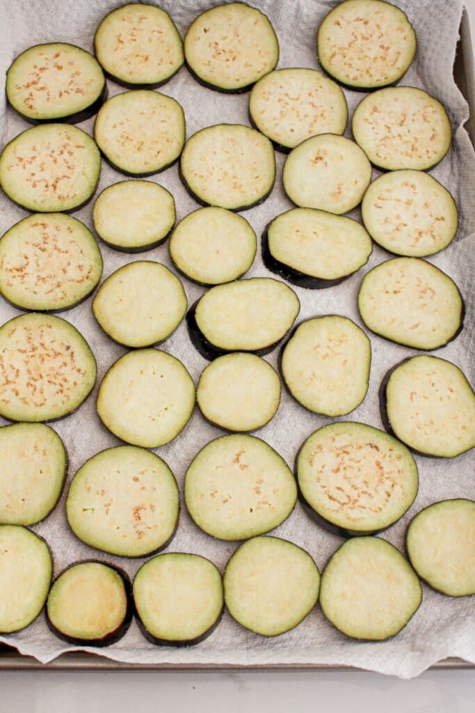 Eggplant slices topped with salt on paper towels.