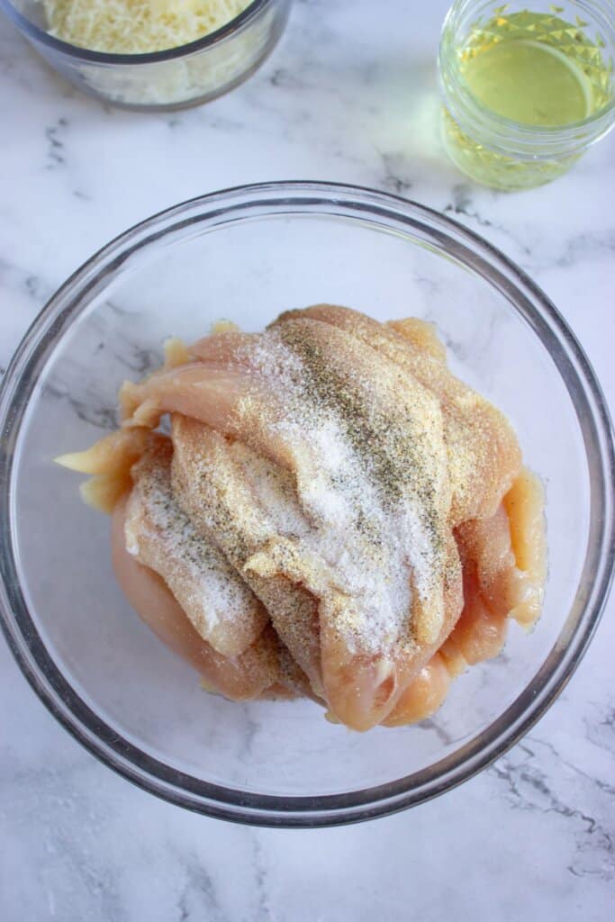 Tenders in a glass bowl topped with seasoning.