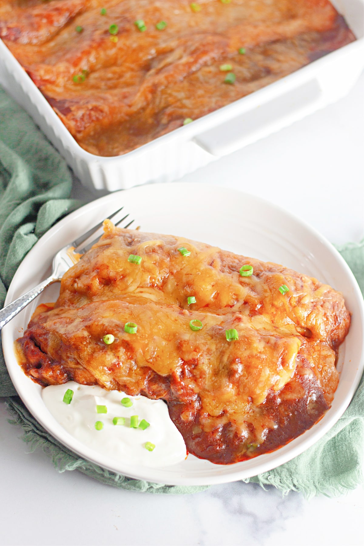 Two ground beef enchiladas on a plate.