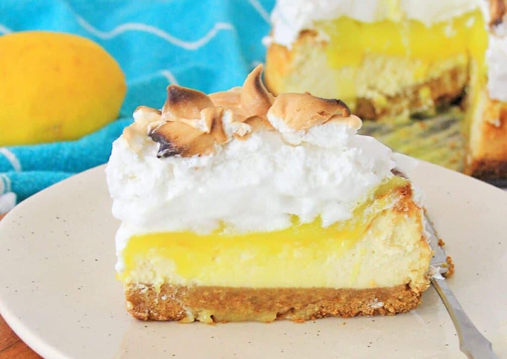 Slice of lemon merginue cheescake on a plate.