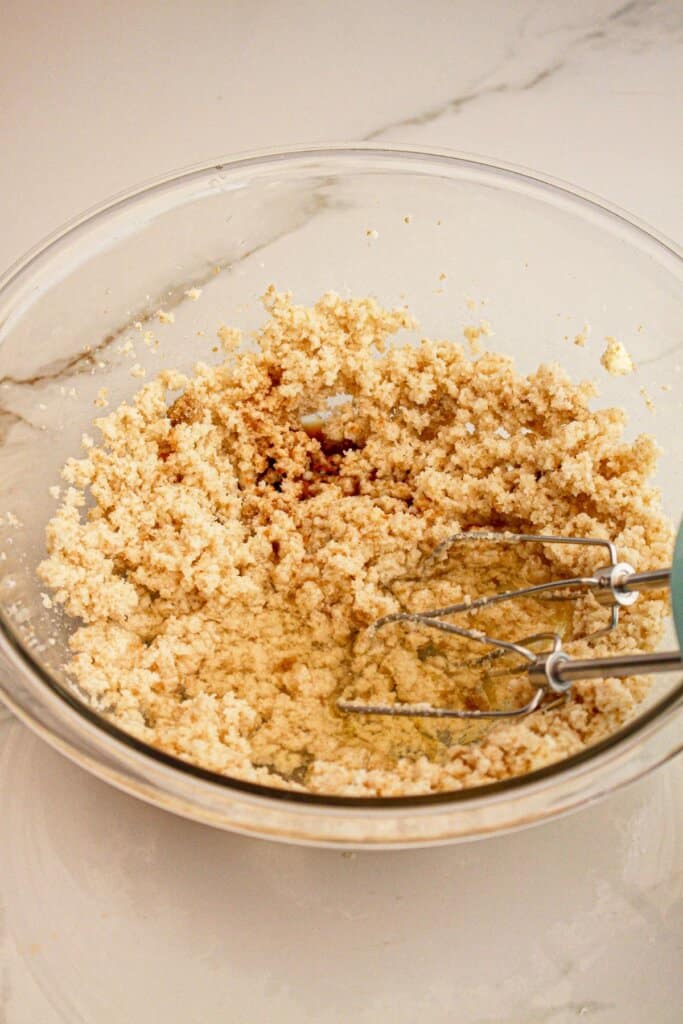 Butter and sugar being mixed in a large mixing bowl.