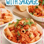 White bowl full of rigatoni with sausage.