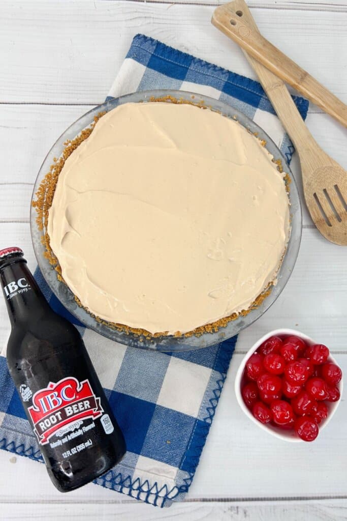 Filling being spread on top of a graham cracker crust.