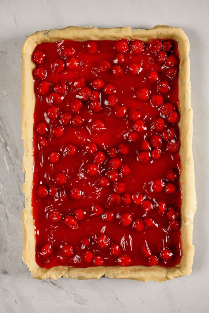 Pie filling spread on top of a crust on a baking dish.