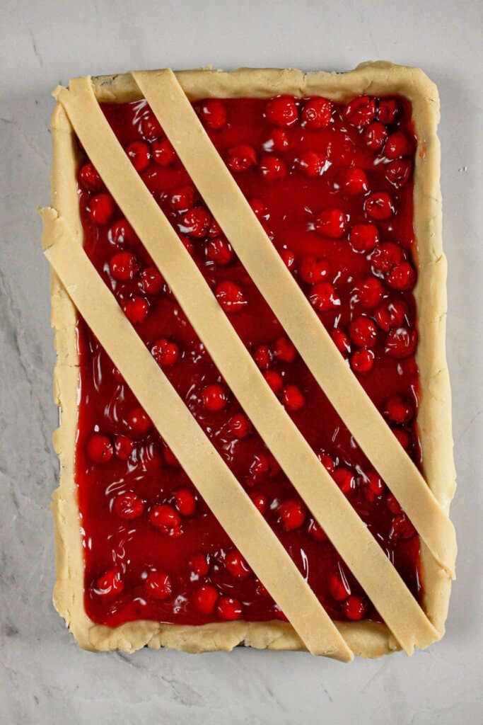 Crust being place on top of dessert in a baking dish.