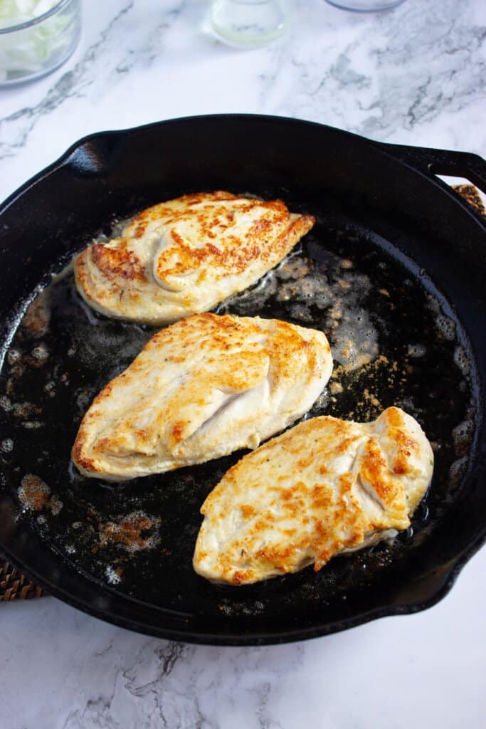 Chicken breasts in a cast iron skillet.