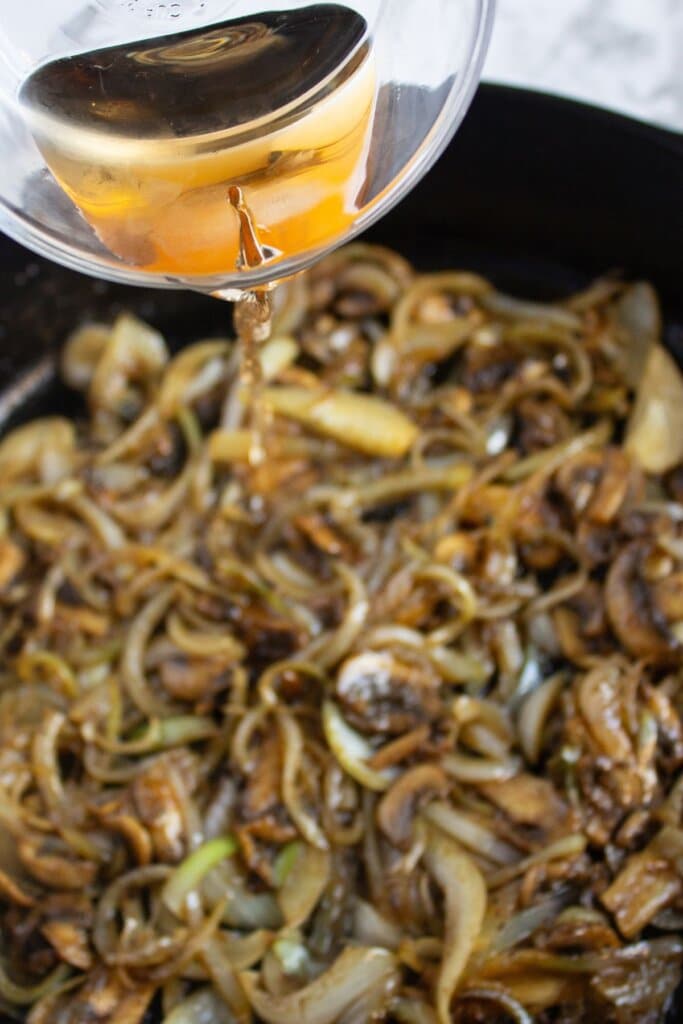Mushrooms and onions in a skillet.