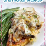 Piece of smothered chicken and green beans on a plate.