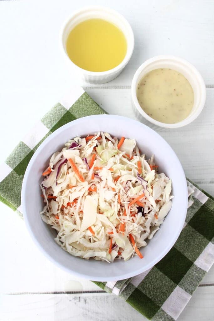 Coleslaw being mixed in a small white bowl.