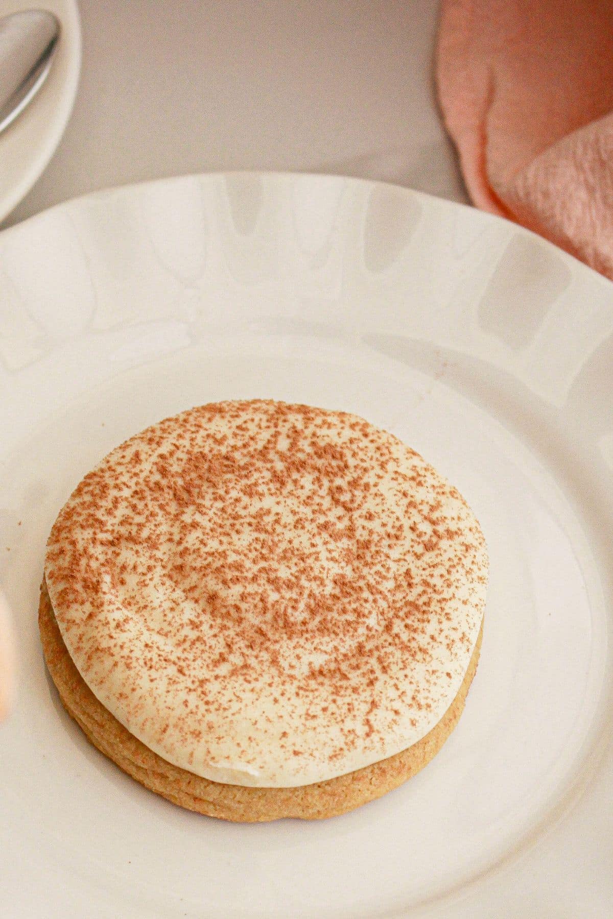 Tiramisu cookie on a plate with the top dusted with cocoa powder.