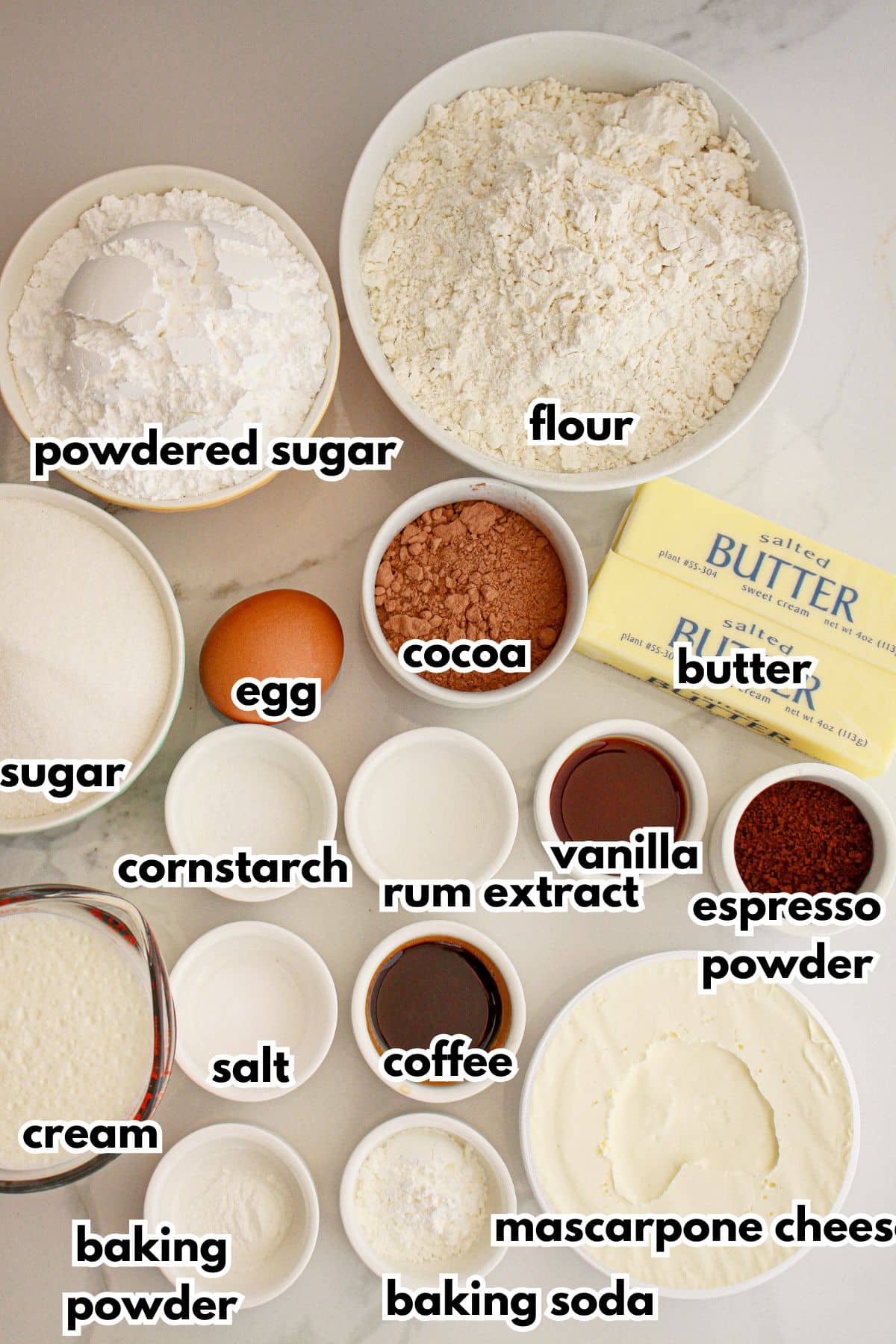 Bowls of ingredients labelled with text on a counter.