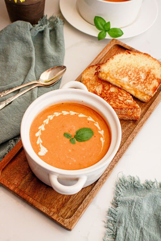 Bowl of soup and a grilled cheese sandwich on a serving tray.