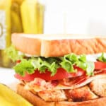 Blackened chicken club sandwiches on a counter.