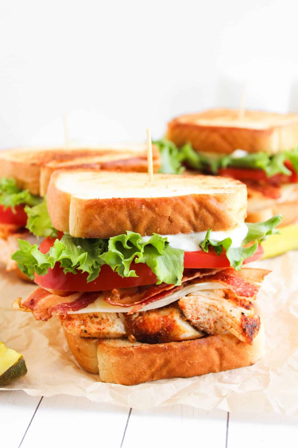 Blackened chicken club sandwiches on a counter.