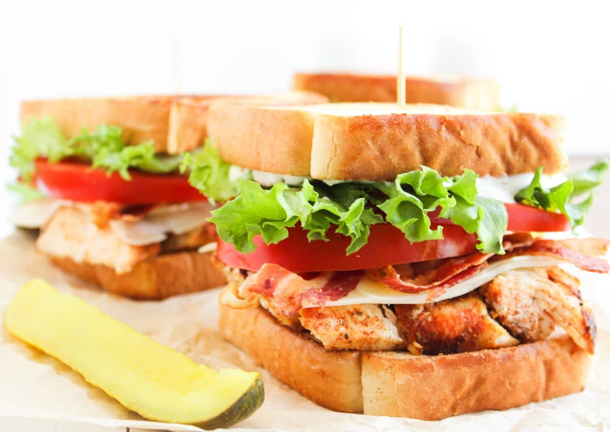 Blackened chicken club sandwiches on a counter.