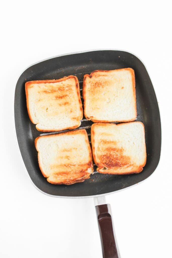 Bread being toasted in a skillet.