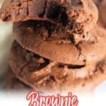 Brownie cookies stacked on top of each other next to a glass of milk.