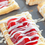 Cherry danishes on a baking sheet.