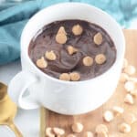 White coffee mug filled with chocolate cake.
