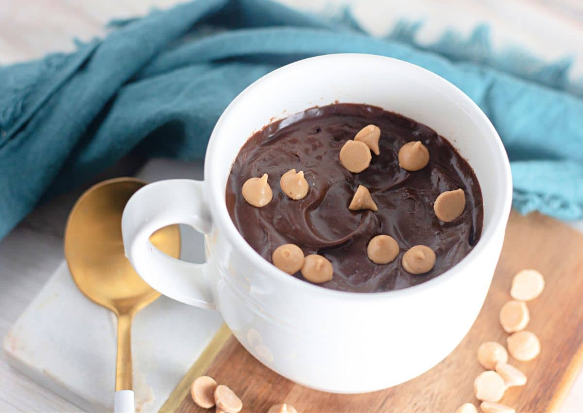 White coffee mug filled with chocolate cake.