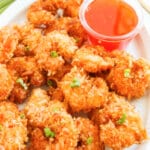 Crispy coconut shrimp on a white serving platter.