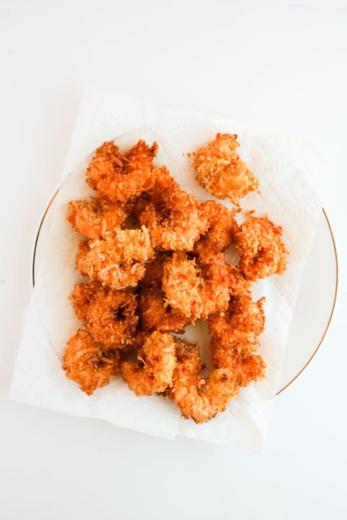 Fried seafood draining on a paper towel lined plate.