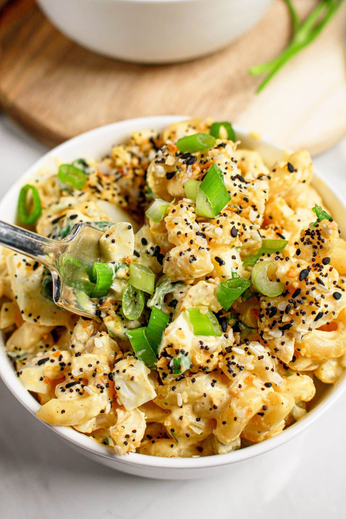 White bowl filled with everything bagel deviled egg pasta salad.