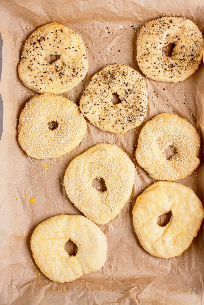 Toppings being added to the top of dough on a baking sheet.