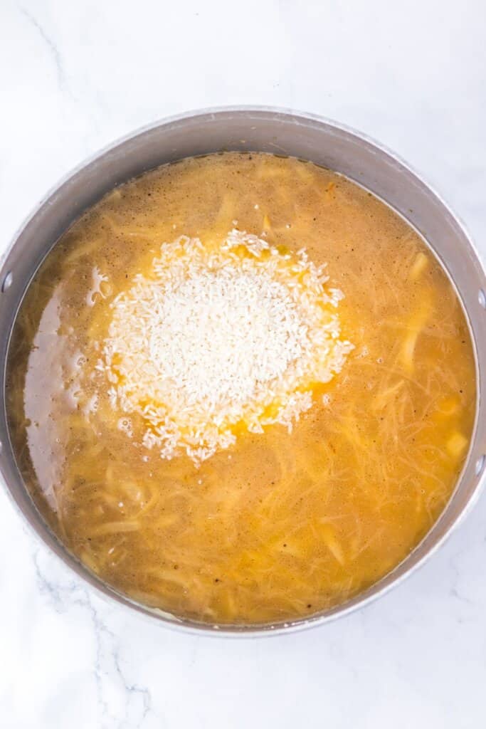 Broth being added to large pot.