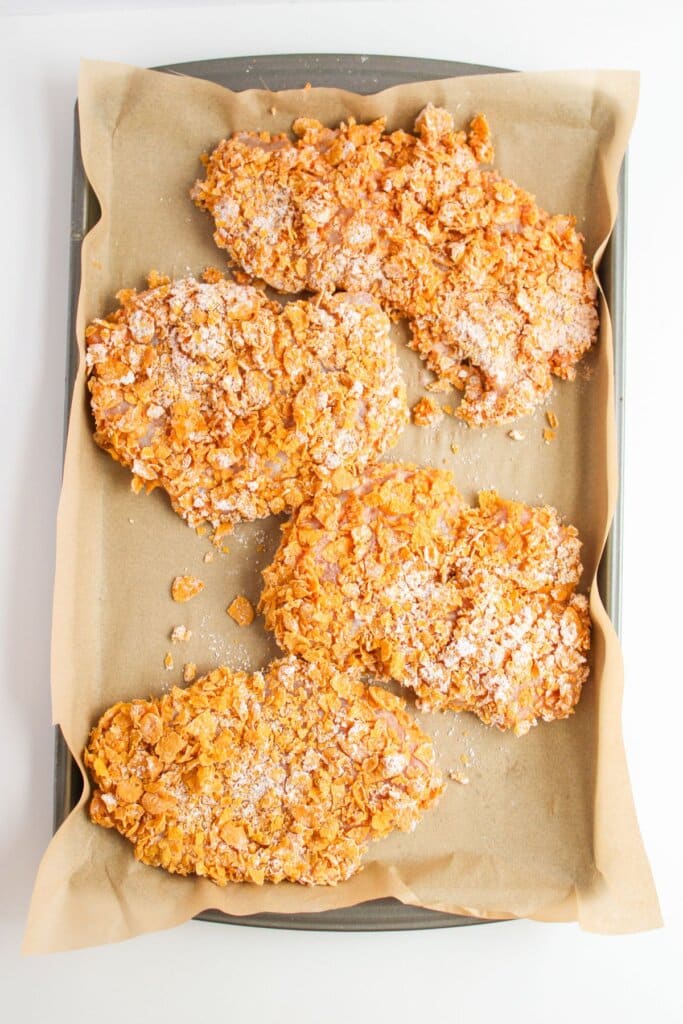 Raw chicken on a baking sheet.