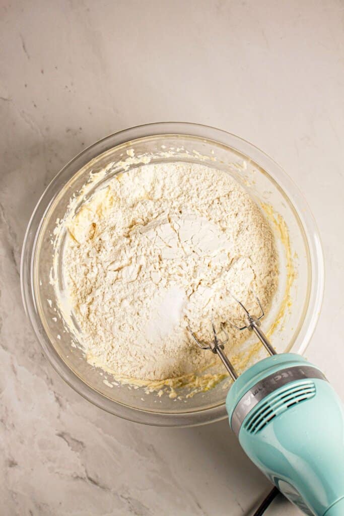 Flour being added to a mixing bowl.