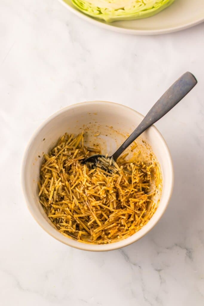 Cheese, oil, and seasonings being mixed in a small bowl.