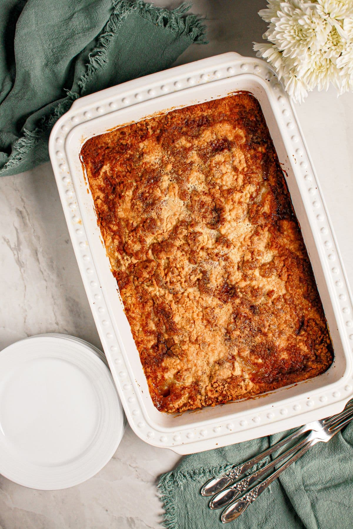 White casserole dish full of baked peach cream cheese dump cake.