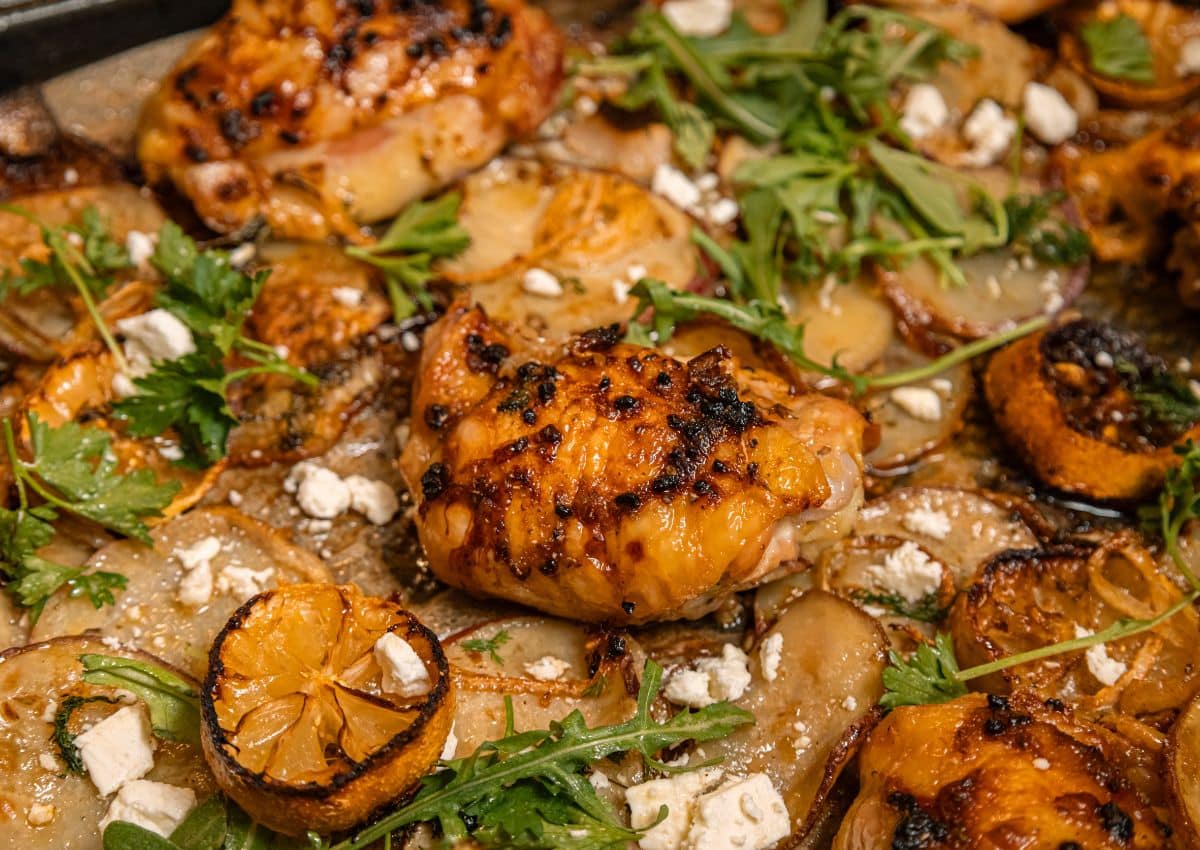 Chicken and vegetables on a baking pan.
