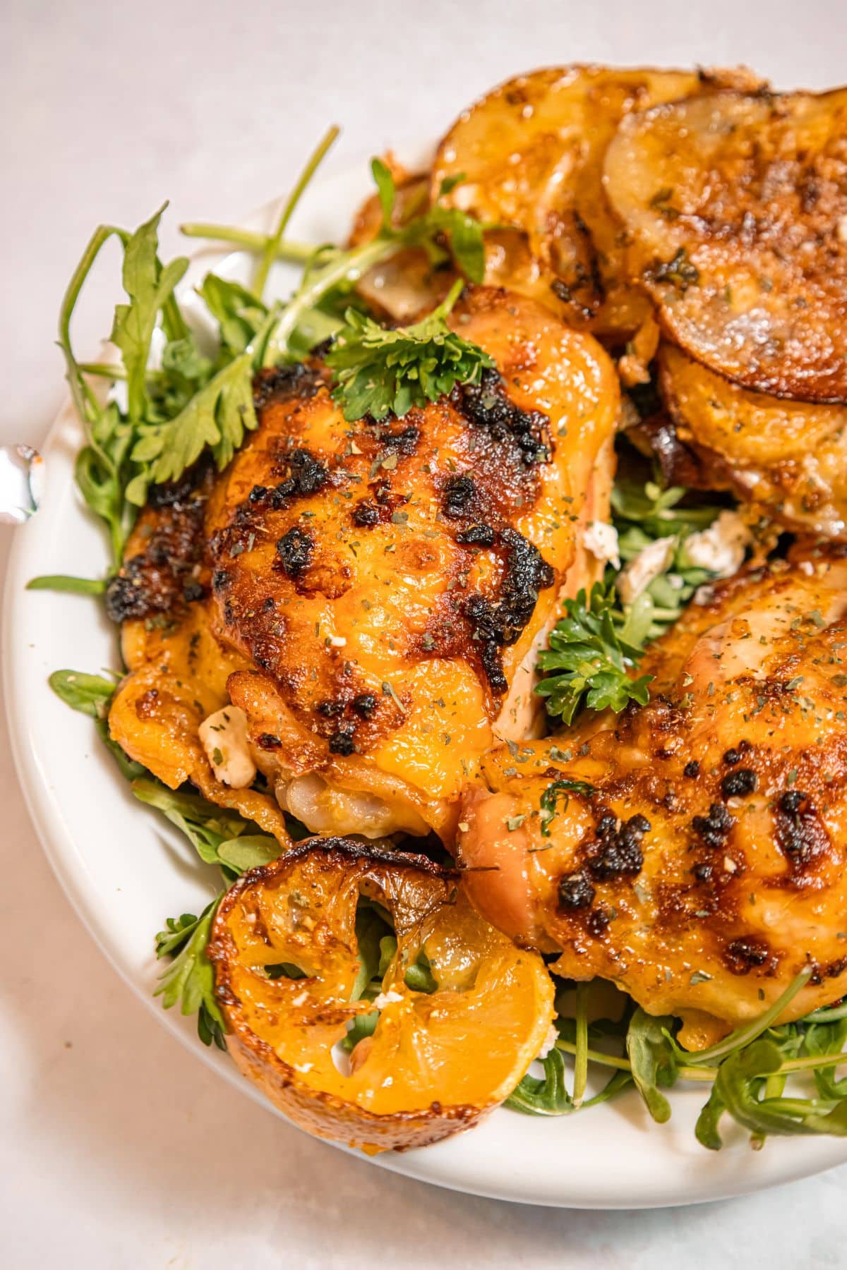 Sheet pan lemon chicken and arugula on a plate.