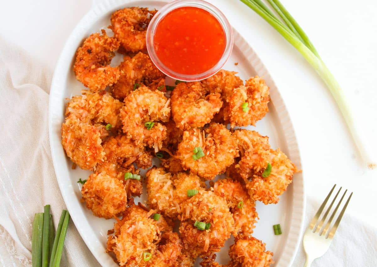 Crispy coconut shrimp on a white serving platter.