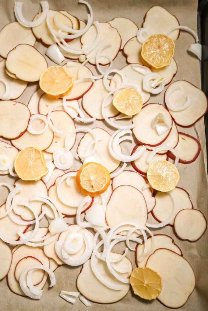 Potatoes and onion slices on a baking dish.