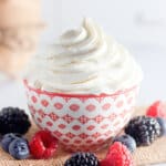 Red and white bowl full of stabilized whipped cream.