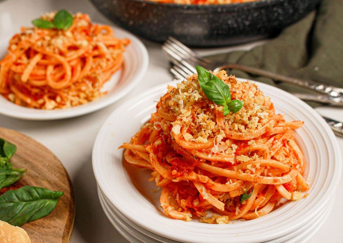 White plate full of a serving of tomato butter pasta.