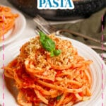 White plate full of a serving on tomato butter pasta.