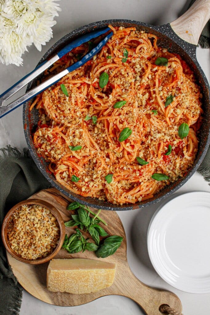 Cast iron skillet full of tomato butter pasta.